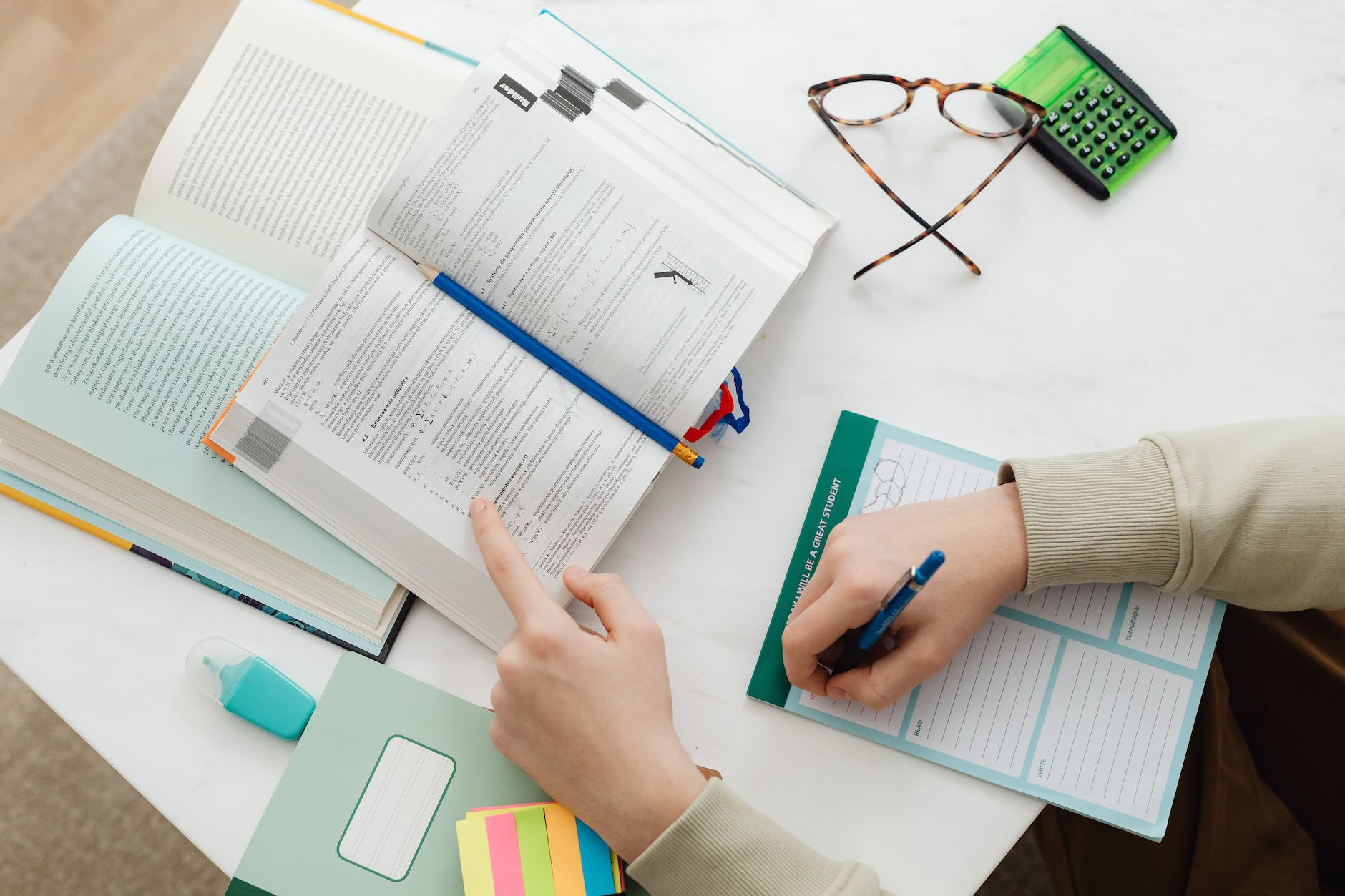 person studying and writing notes on paper